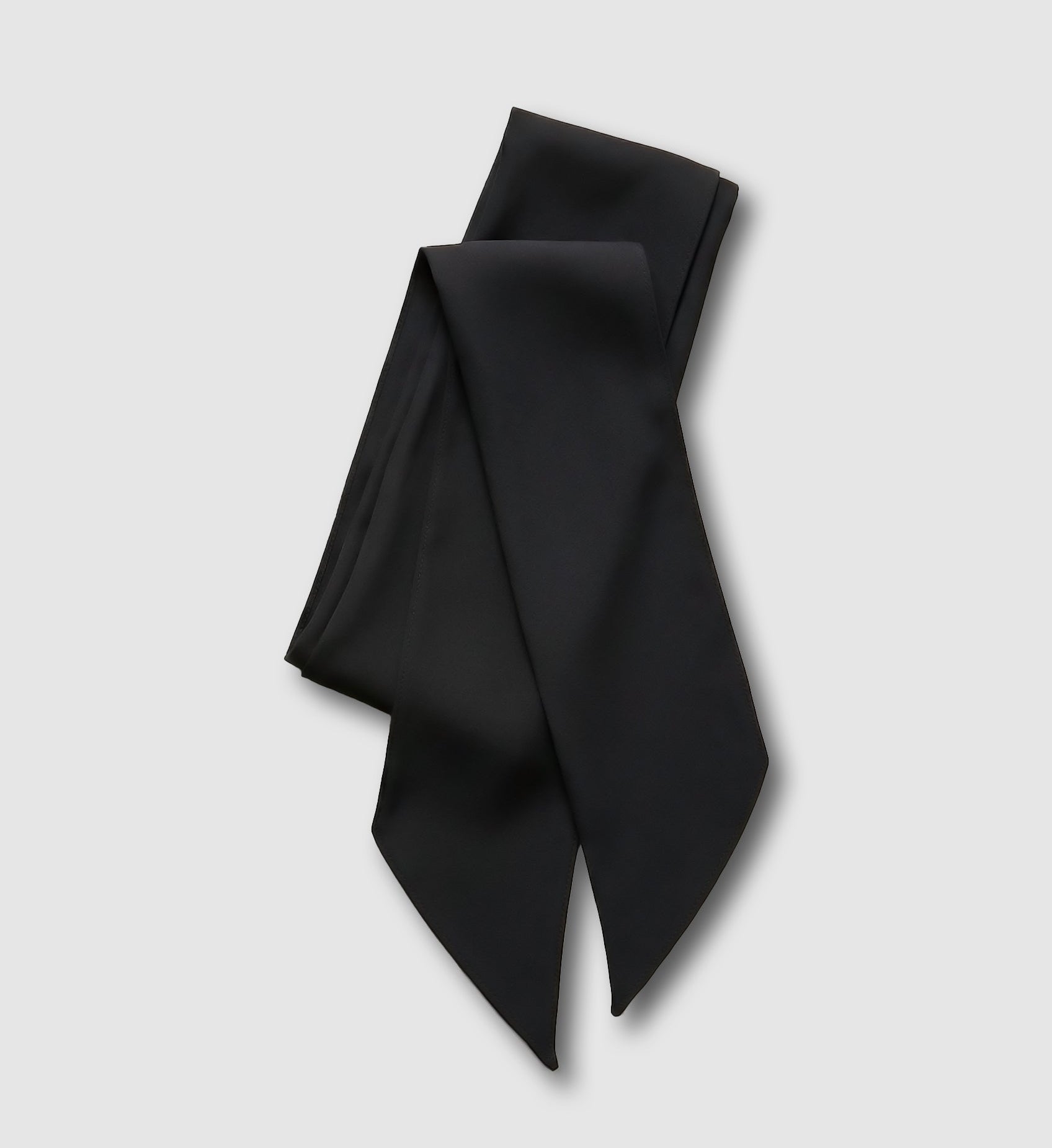 Black silk scarf folded on a grey background