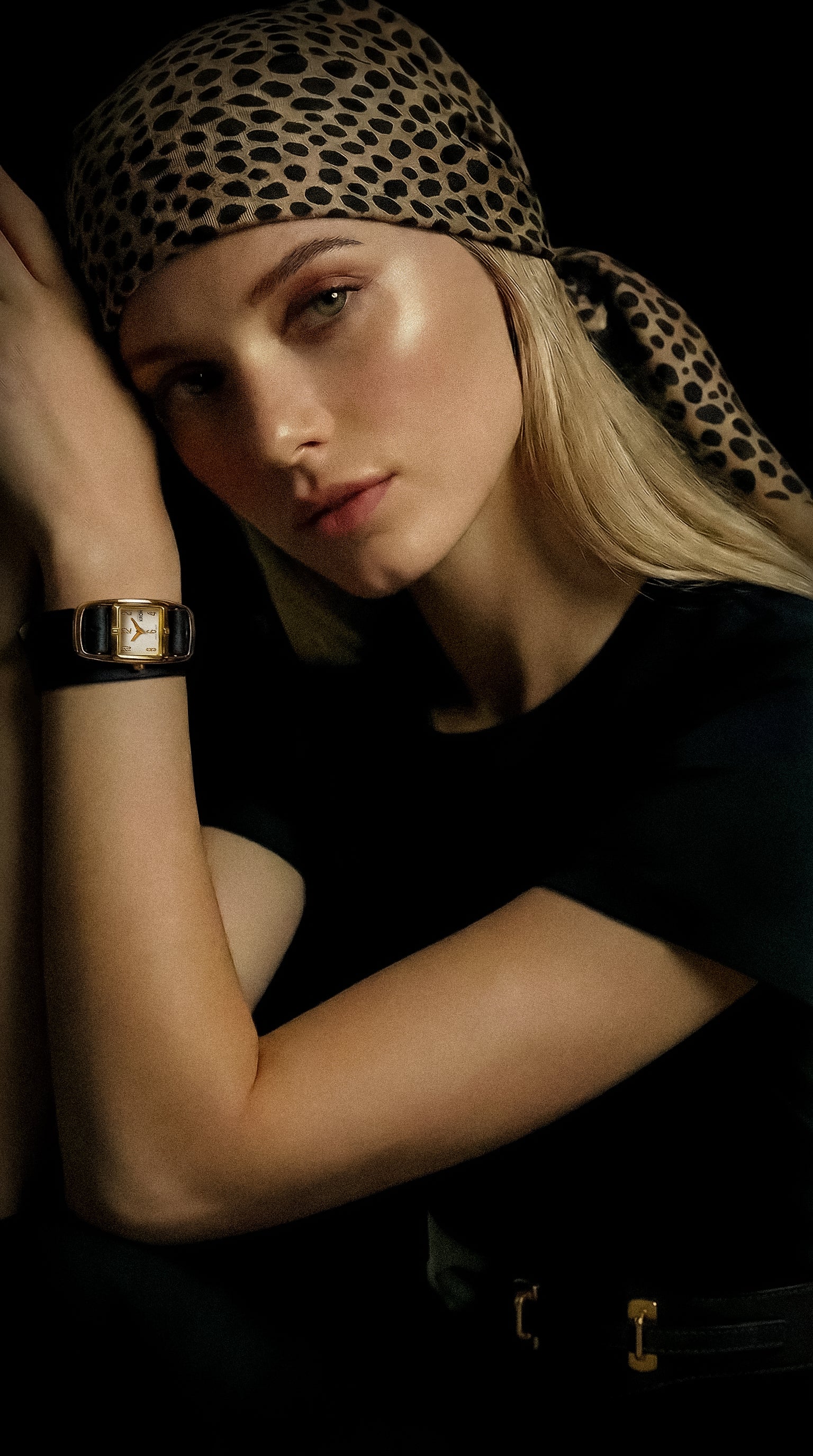 Woman wearing a leopard print headscarf with a dark background