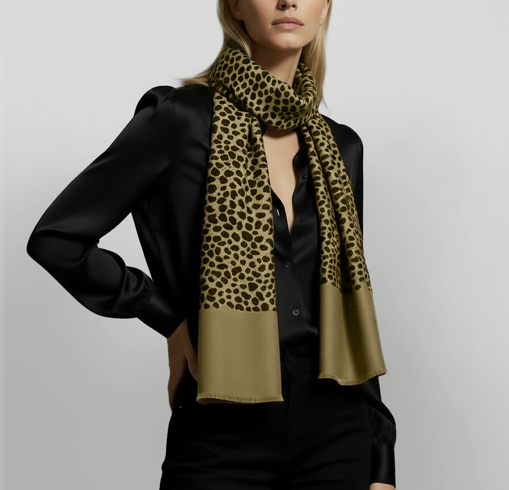 Person wearing a leopard print scarf with a black and green color scheme on a plain background