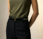 Model wearing the Isabella Kron Brea Belt in black leather studded with gold-tone hardware, featuring rectangular buckle and studs