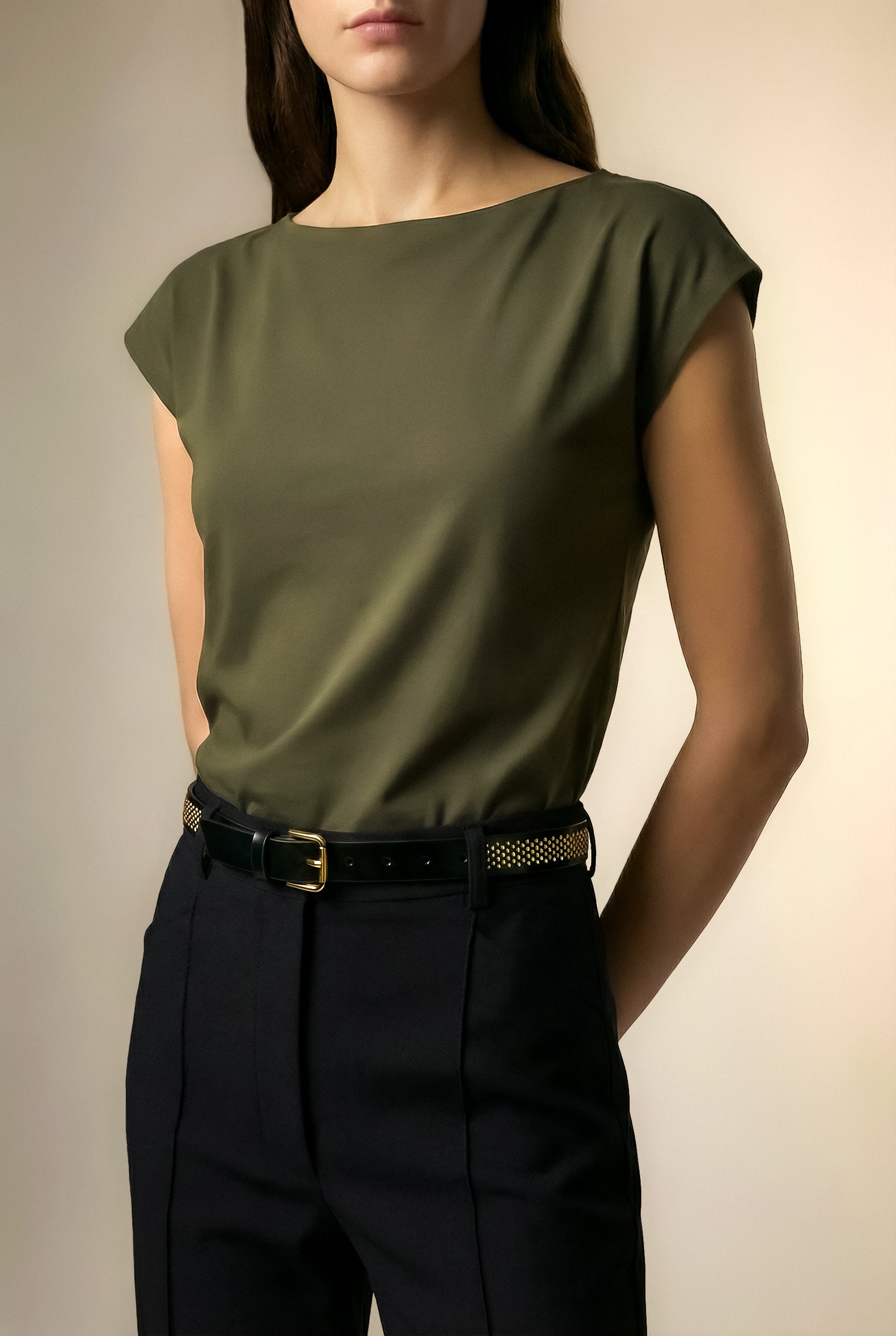 Model wearing the Isabella Kron Brea Belt in black leather studded with gold-tone hardware, featuring rectangular buckle and studs