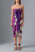 Model wearing the Isabella Kron Butterflywing Pareo in purple, a lightweight Made in Italy cotton voile beach wrap styled as an elegant resort cover-up.