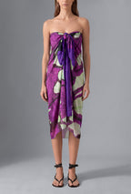 Model wearing the Isabella Kron Butterflywing Pareo in purple, a lightweight Made in Italy cotton voile beach wrap styled as an elegant resort cover-up.