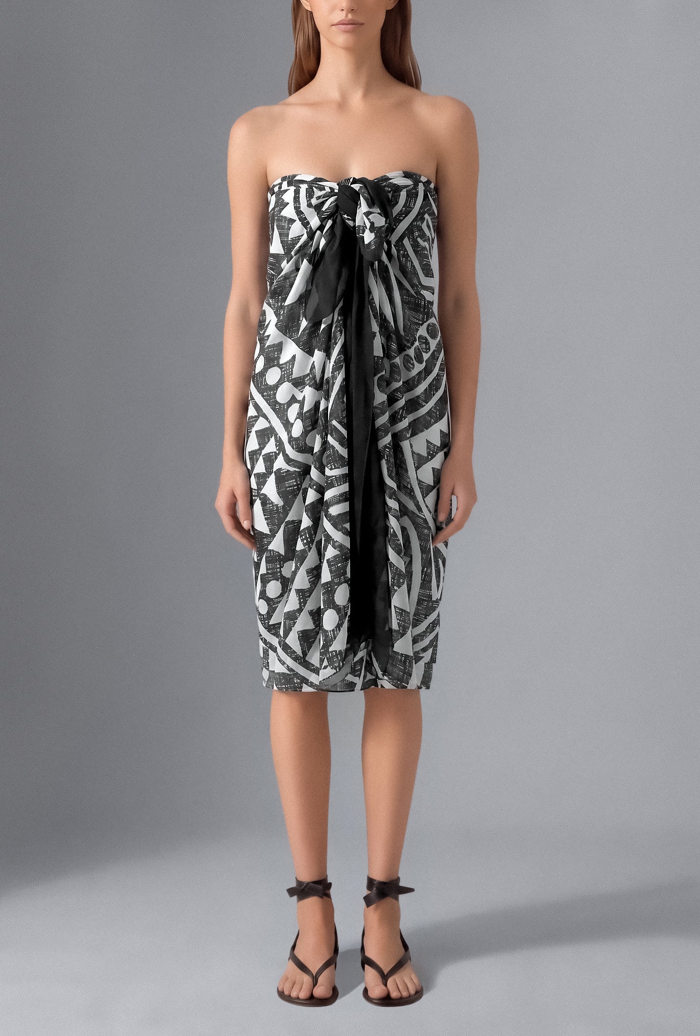 Model wearing the Isabella Kron Graffito Pareo in Black & White, crafted in Italy from lightweight cotton voile and styled as an elegant strapless resort cover-up.