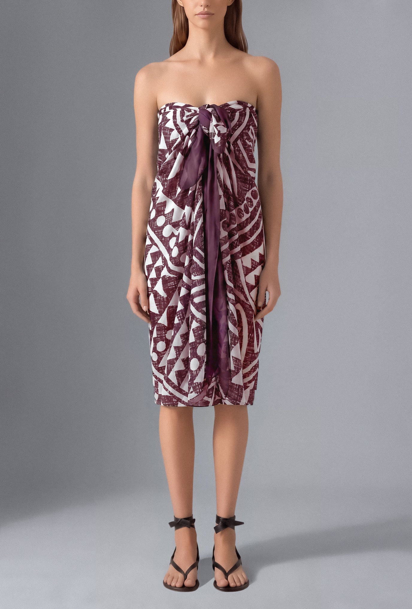 Model wearing the Isabella Kron Graffito Pareo in Bordeaux & White, crafted in Italy from lightweight cotton voile and styled as an elegant strapless resort cover-up.