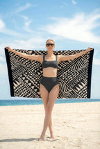 Black and milk geometric beach towel woman holding it open