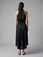 Back view of the Lily black silk midi skirt with a gathered silhouette and smocked waist