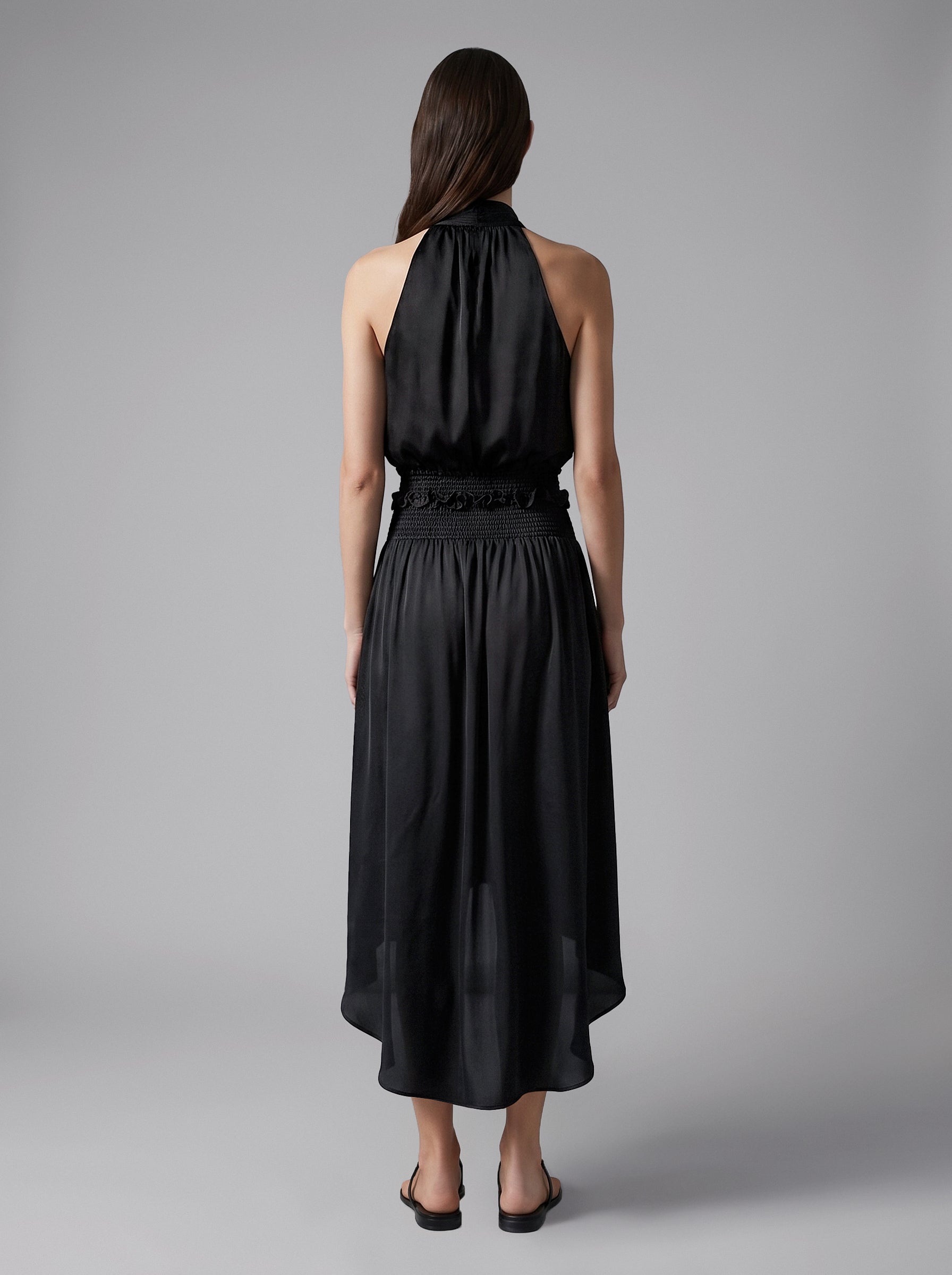 Back view of the Lily black silk midi skirt with a gathered silhouette and smocked waist