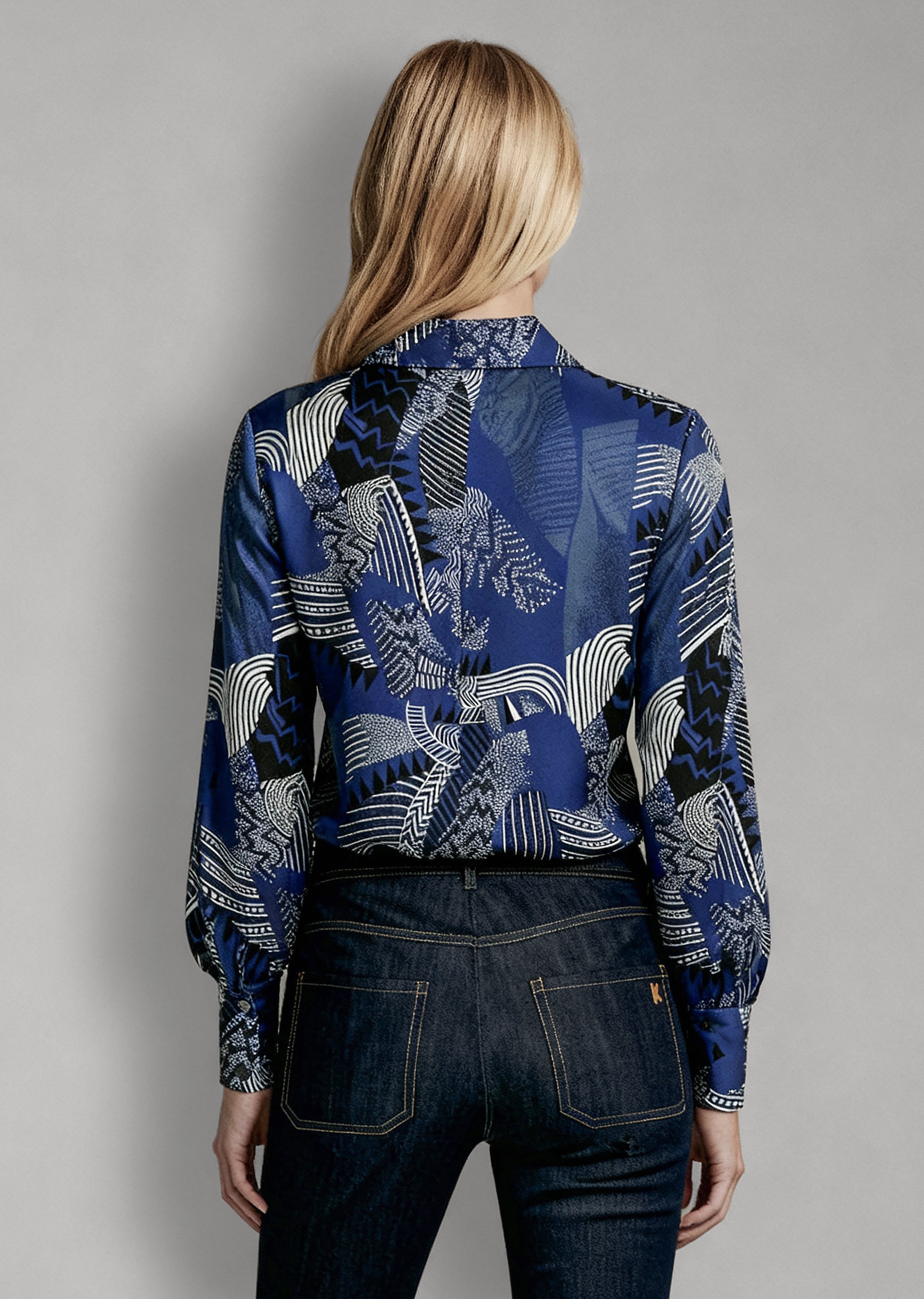 Back view of Isabella Kron Linda Shirt in black iris print, showcasing central back pleat and striking botanical design