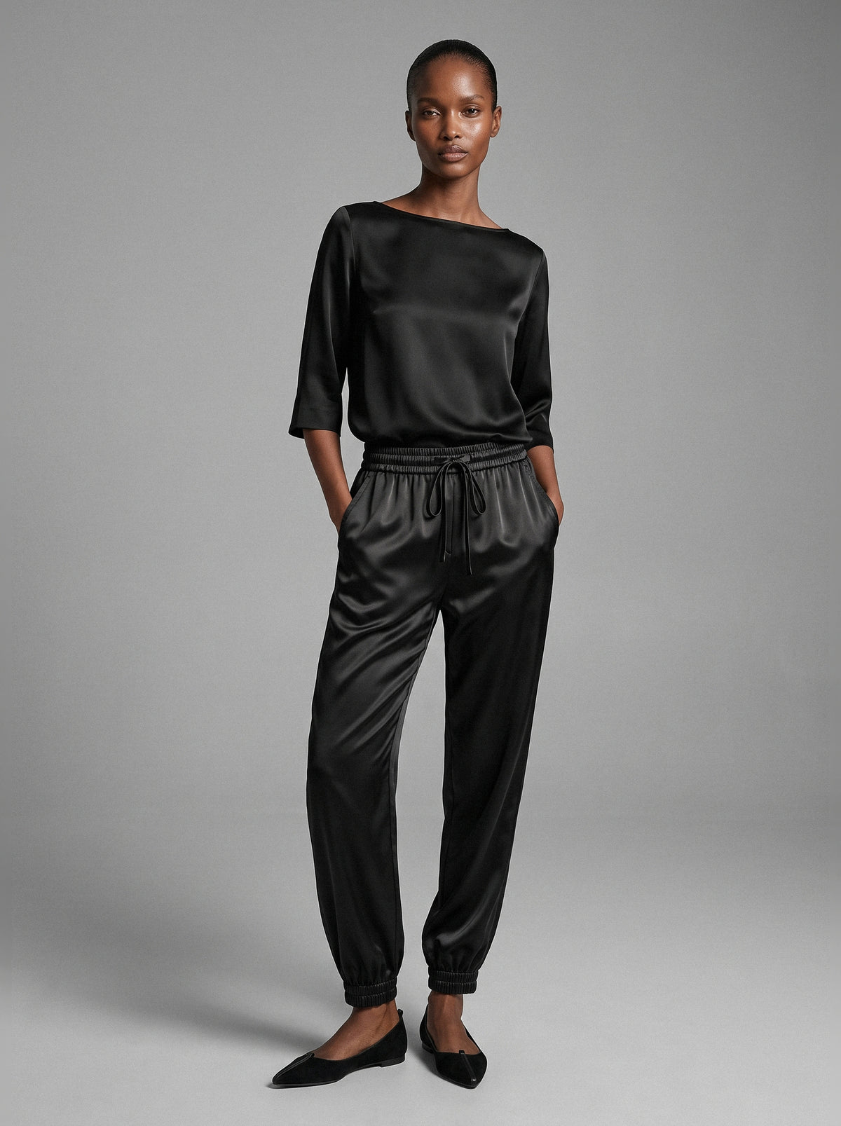 Model wearing the Lou Jogger Silk Pant in black, a relaxed-fit silk jogger with a drawstring waist and elastic cuffs, front view