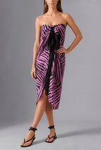 Full-length view of Savana Pareo in Fuchsia styled as a modern luxury beach wrap