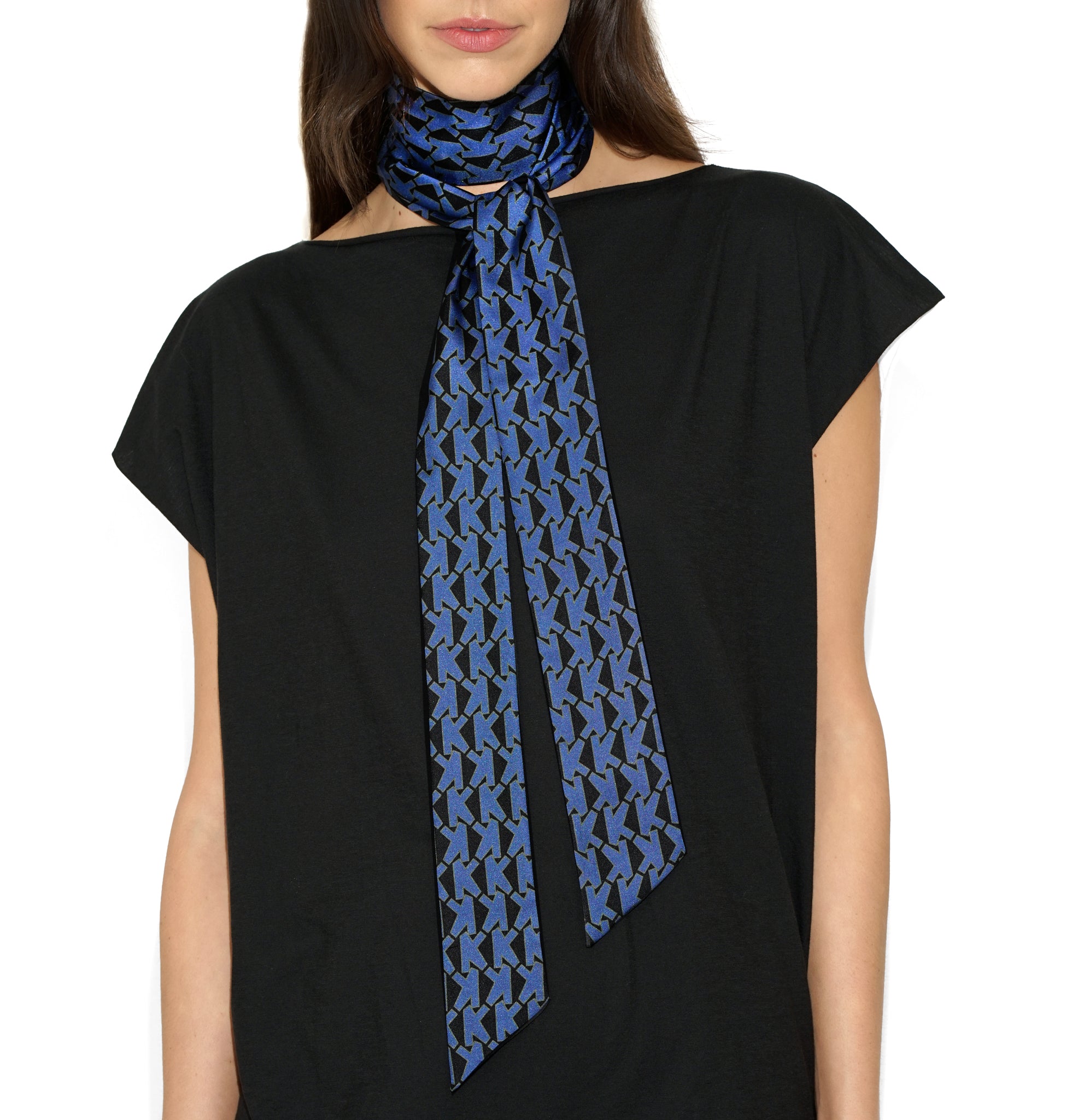 Styled view of Alice K Scarf in vivid blue tied in a knot at the front, worn gracefully over a t-shirt to illustrate polished silk elegance
