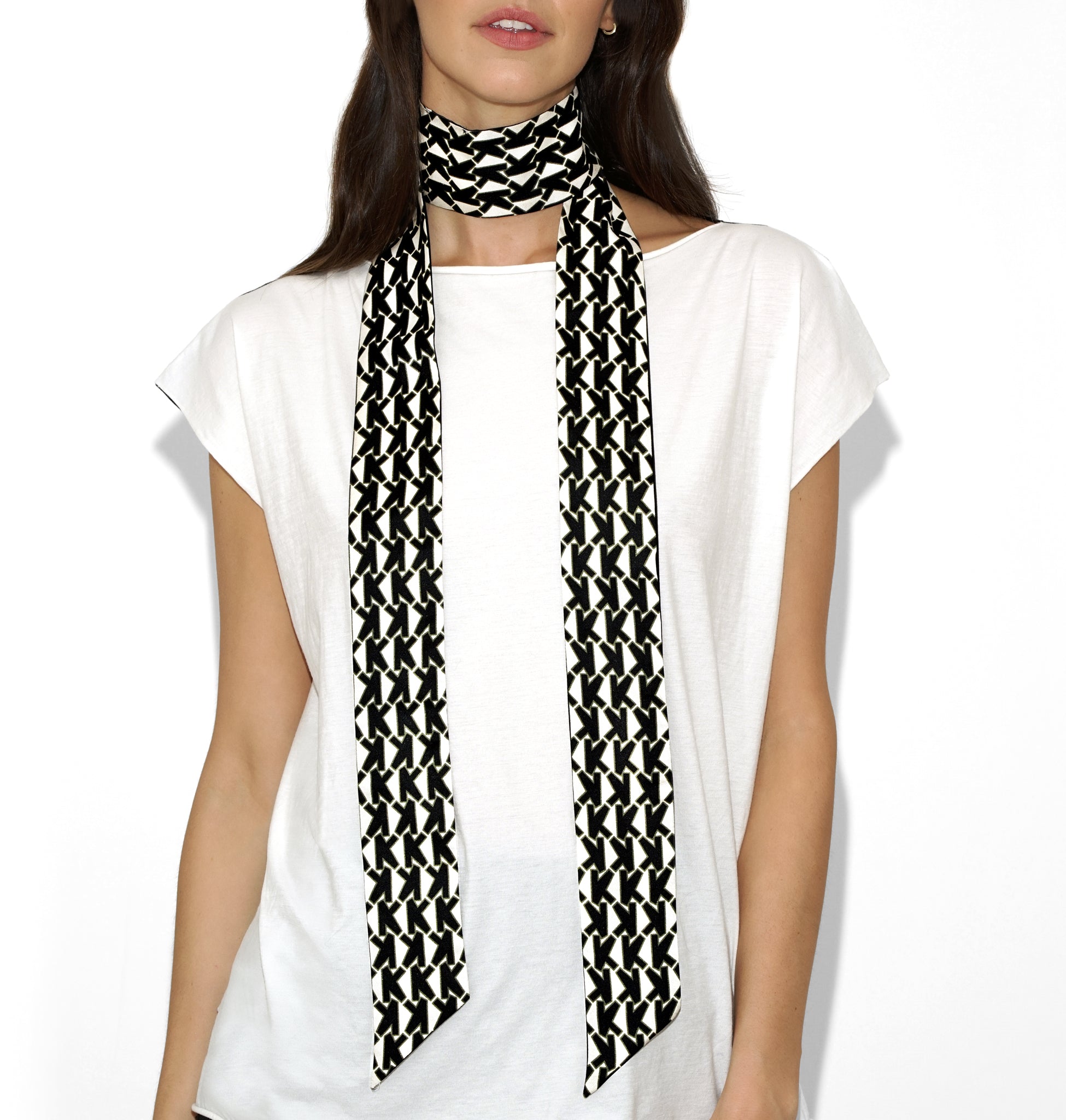 Front draped view of Isabella Kron Alice Scarf in black and white, loosely worn around the neck showcasing bold graphic pattern and smooth silk texture