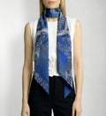 Front draped view of Isabella Kron Joni silk scarf in black iris print, loosely wrapped around the neck showing fluid drape and vibrant floral pattern