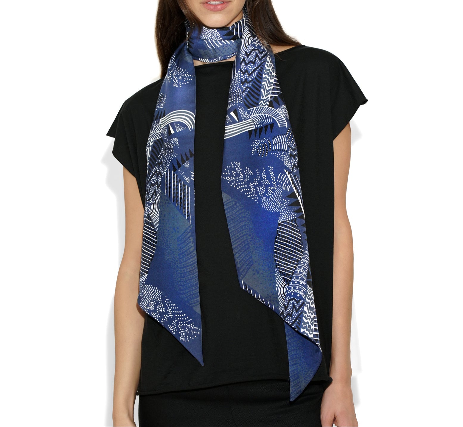 Front draped view of Isabella Kron Joni silk scarf in black iris print, loosely wrapped around the neck showing fluid drape and vibrant floral pattern