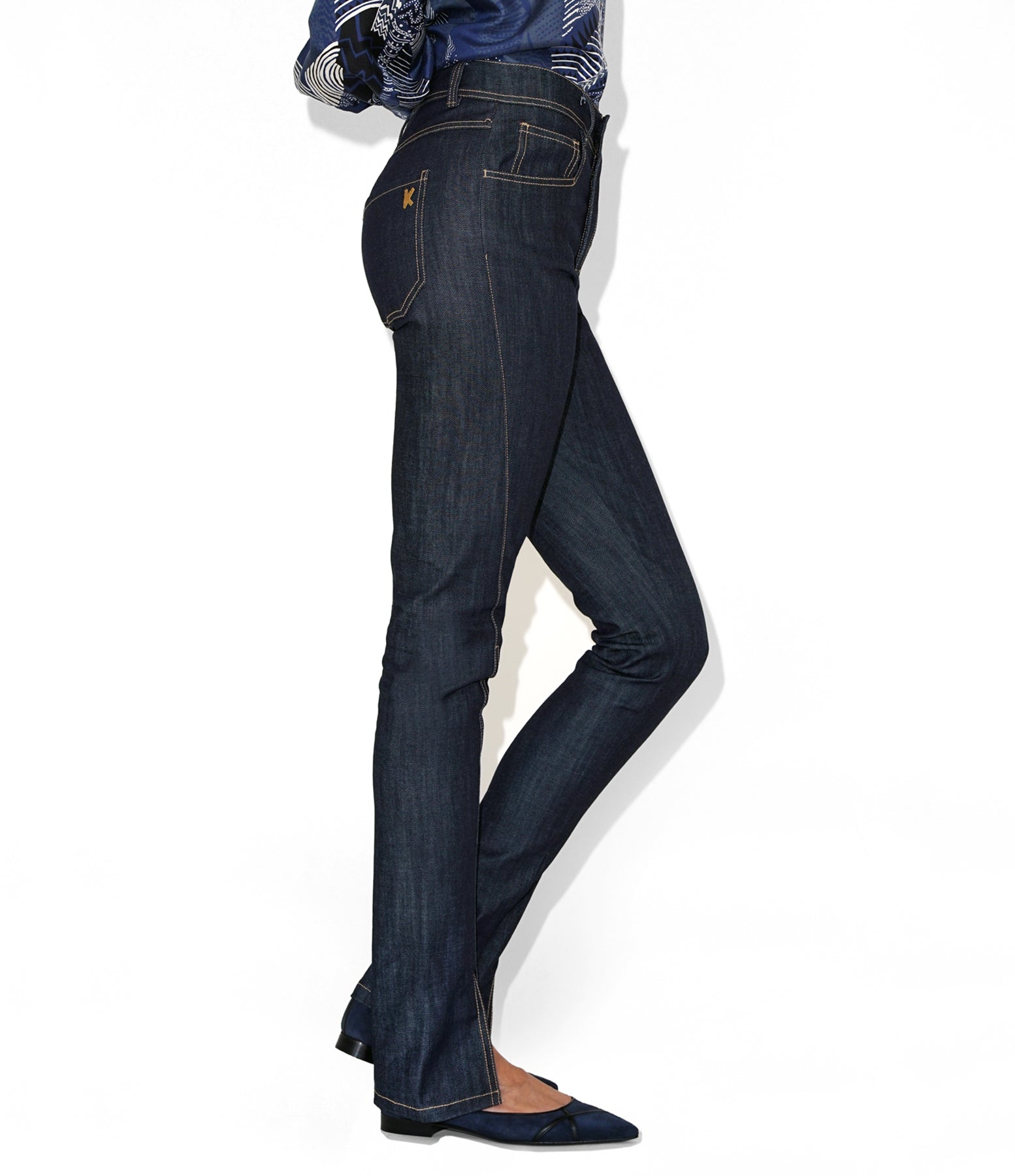 Side view of Isabella Kron K‑22 Jean in dark indigo worn by model, showcasing mid-rise waist and slender leg silhouette