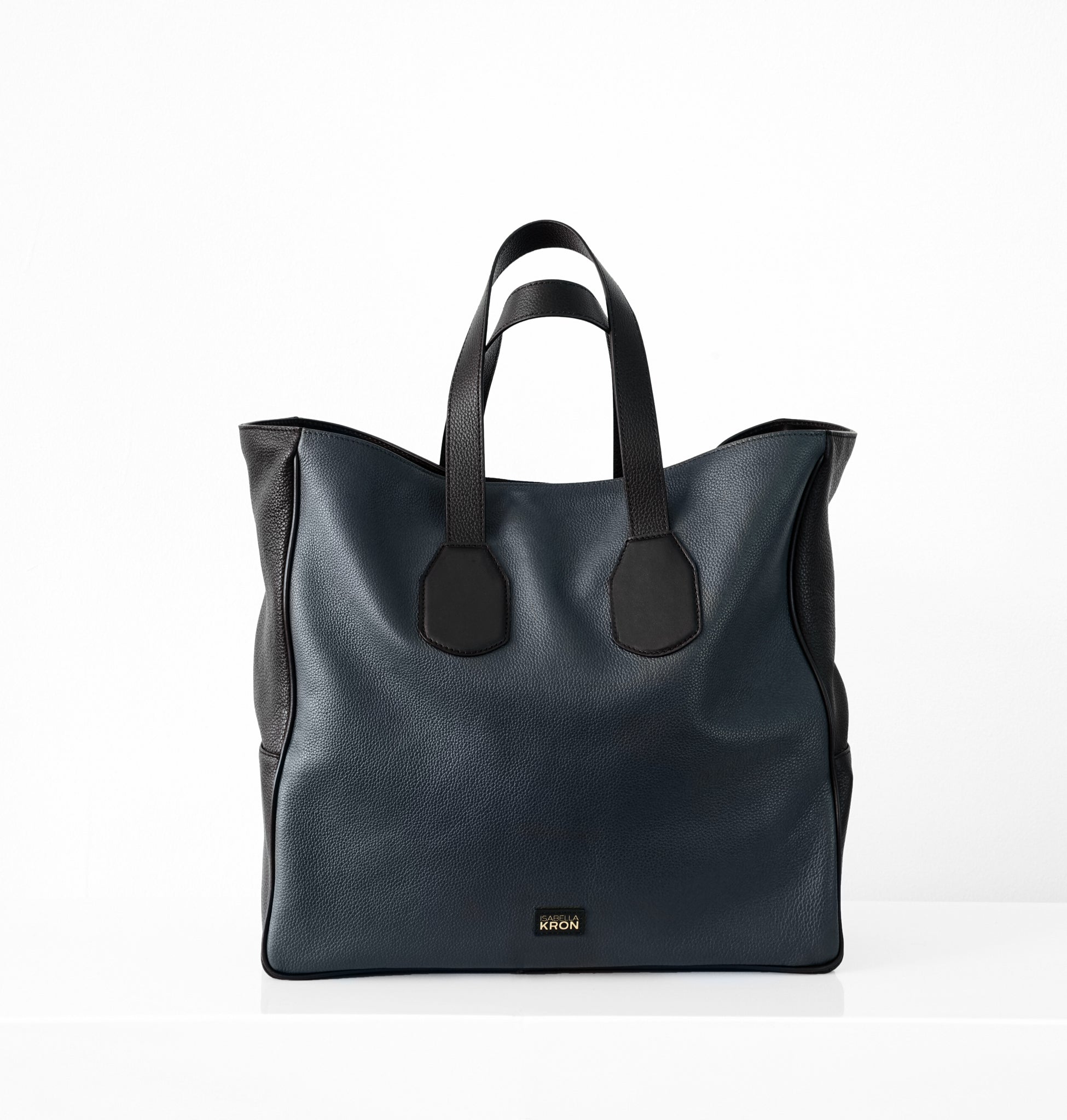 Upright front view of Isabella Kron Leo Shopper in blue pebbled leather with black contrast trim, structured silhouette with double handles and subtle branding