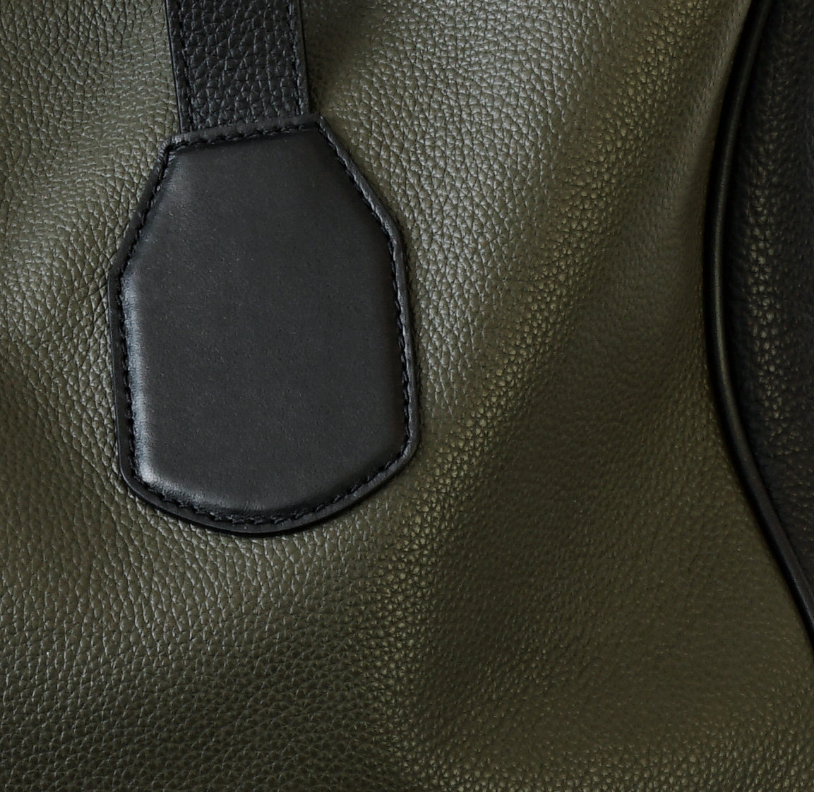 Close-up of reinforced bottom corner, black leather trim, and visible stitching on Isabella Kron Leo Shopper in military green leather