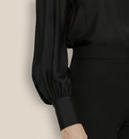 Close-up of silk sheen and glossy buttons on cuff and collar of Isabella Kron Linda silk shirt in black