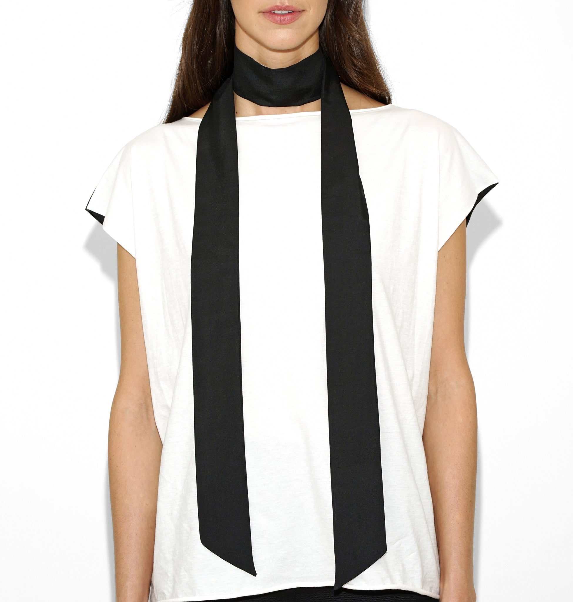 Front view of Isabella Kron Nina silk scarf in black, draped loosely around the neck showing smooth silk sheen and long rectangular shape